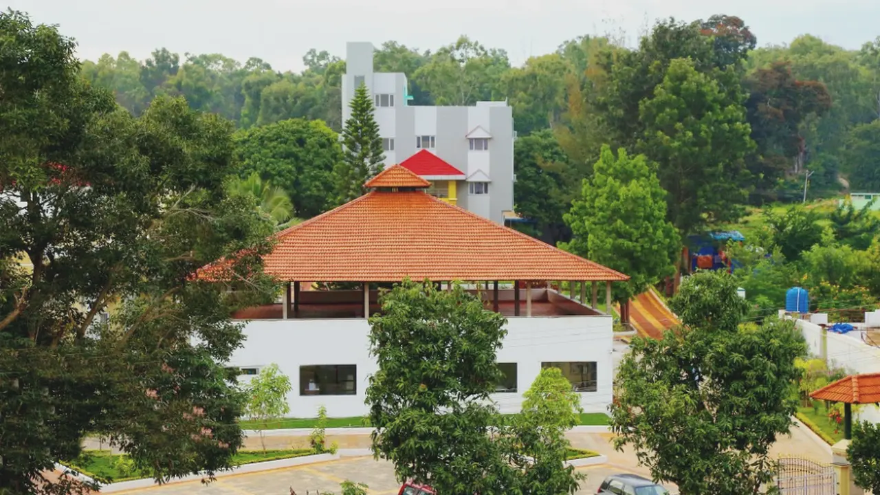 The tiled roof of the restaurant block and the trees beyond it, seen from the front of Hotel Hills Yelagiri