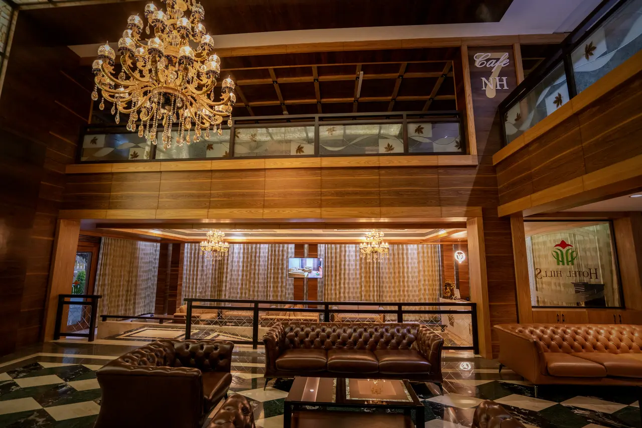 The lounge at Hotel Hills Hosur, leather sofas on the chequered marble floor