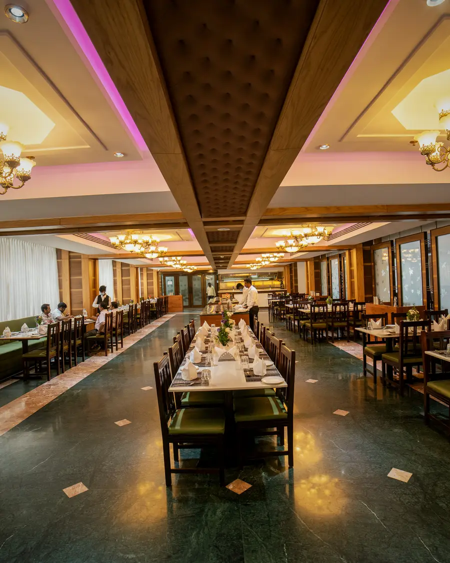 The Copper Bowl restaurant at Hotel Hills Hosur, tables laid down the length of the room