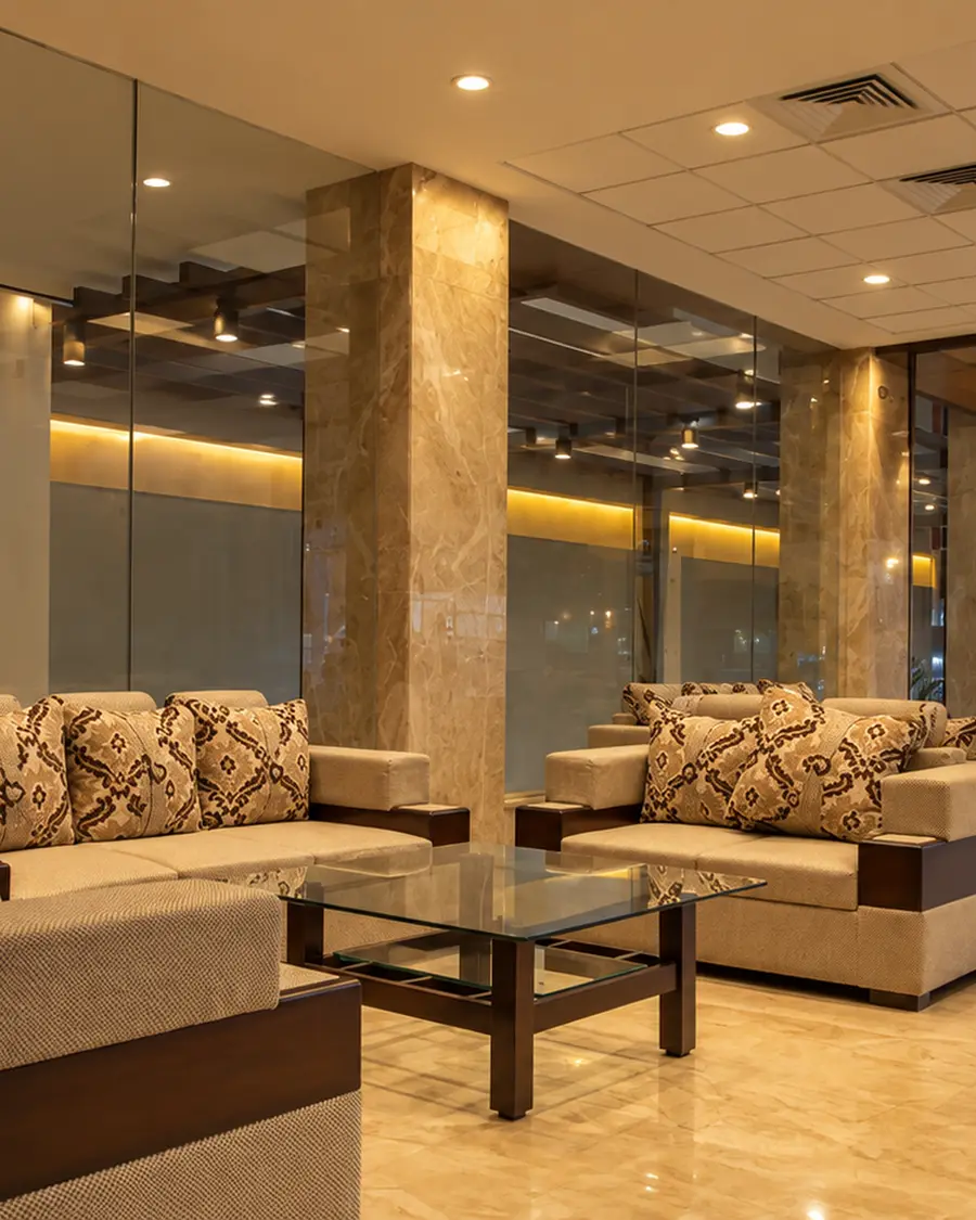 The lobby at Hotel Hills Tirupattur, sofas either side of a polished stone floor