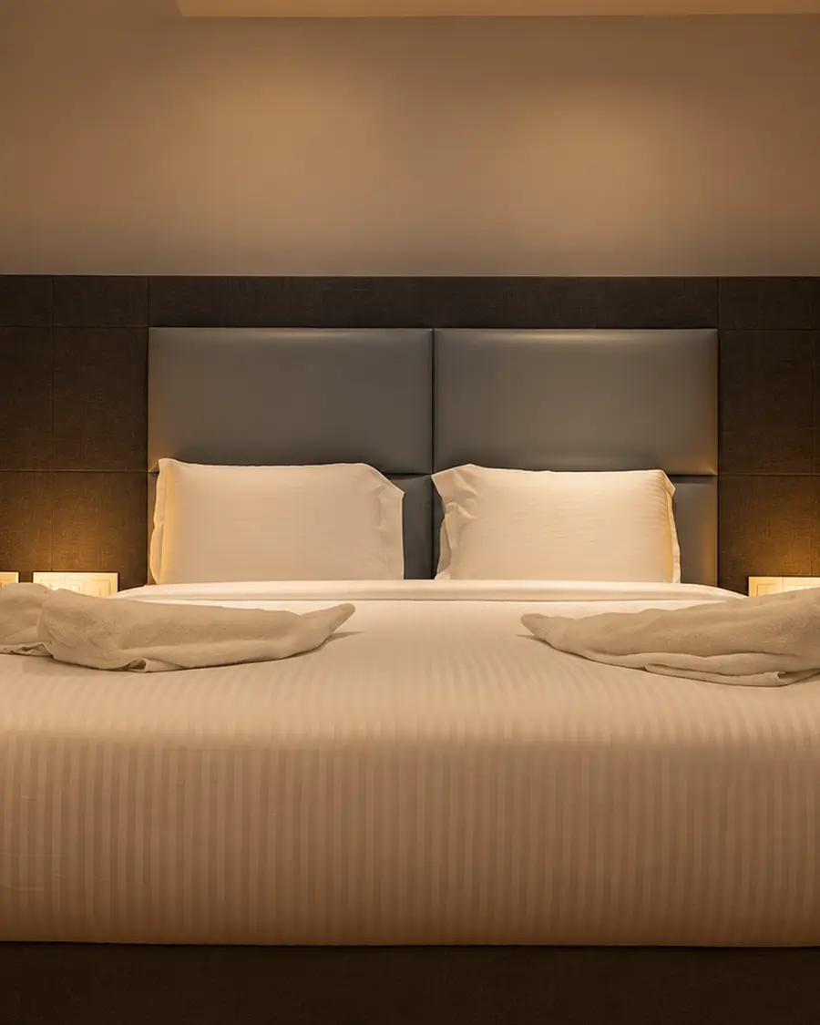 A king bed with a grey padded headboard at Hotel Hills Tirupattur